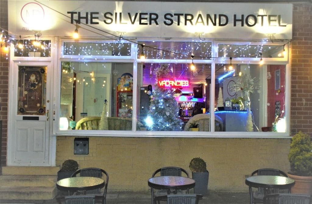 Hotel Silver Strand con un árbol de Navidad y un letrero de neón.