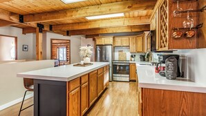 A kitchen with wooden cabinets, stainless steel appliances, and a white countertop. - Lodge at Summit Park Near Woodward (Park City)