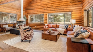 A log cabin interior with a fireplace, leather sofas, and large windows. - Lodge Hot Tub Dueling Basketball (Park City)