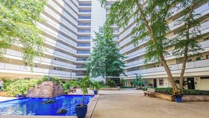 A courtyard with a swimming pool, benches, and potted plants. - Sea Watch- Penthouse, Oceanfront 4 BR, two floors (Ocean City)