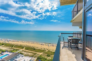 A balcony with a view of the beach and ocean, a pool, and outdoor seating. - Sea Watch- Penthouse, Oceanfront 4 BR, two floors (Ocean City)