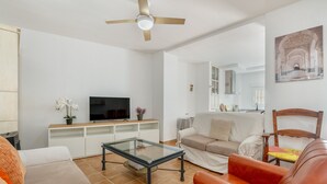 A living room with a television, sofa, coffee table, and a ceiling fan. - Casa Mercedes for Large Families. Air Conditioning (Valderrubio)
