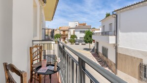 A balcony with a wooden chair, a small table, and a potted plant. - Casa Mercedes for Large Families. Air Conditioning (Valderrubio)