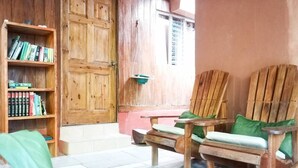 Eine Holztür, ein Bücherregal und zwei Holzstühle mit Kissen.