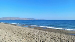 Ein Strand mit blauem Himmel und ruhigem Meer.