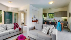 Ein modernes Wohnzimmer mit zwei Sofas, einem Essbereich und einer Küche.