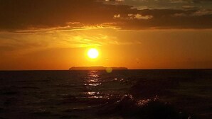 A sunset over a body of water with a distant landmass. - Casita happy feet and tours corcovado - Family Room with Garden View (Bahía Drake)