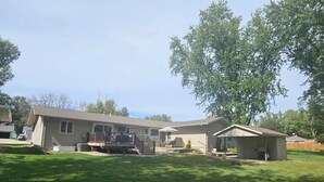 A two-story house with a covered patio and a fenced yard.