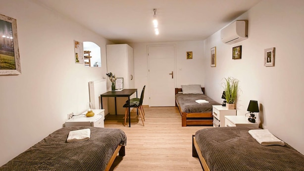 A room with two single beds, a desk, a chair, a small table, and a couch. - Double rooms - r no.4 (Cianowice)