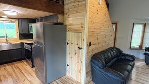 A modern kitchen with a built-in refrigerator and wooden walls.