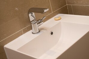 A bathroom sink with a chrome faucet and a soap dish. - Cozy City Retreat in London (London)