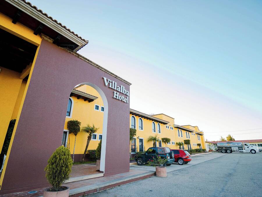 Un edificio amarillo con un letrero que dice "Villalba Hotel".