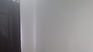 Ein Hotelzimmer mit Bett, Vorhang und einem bettfertigen Schwanentowel.