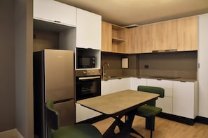 Departamento junior, balcón | Cocina privada | Refrigerador con congelador, microondas, horno y parrilla de estufa