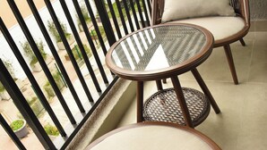 A balcony with wicker furniture, including two chairs and a small round table. - APART HOTEL HW COMPAÑIA (Santiago)