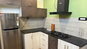 A kitchen with a stainless steel refrigerator, a gas stove, and wooden cabinets.