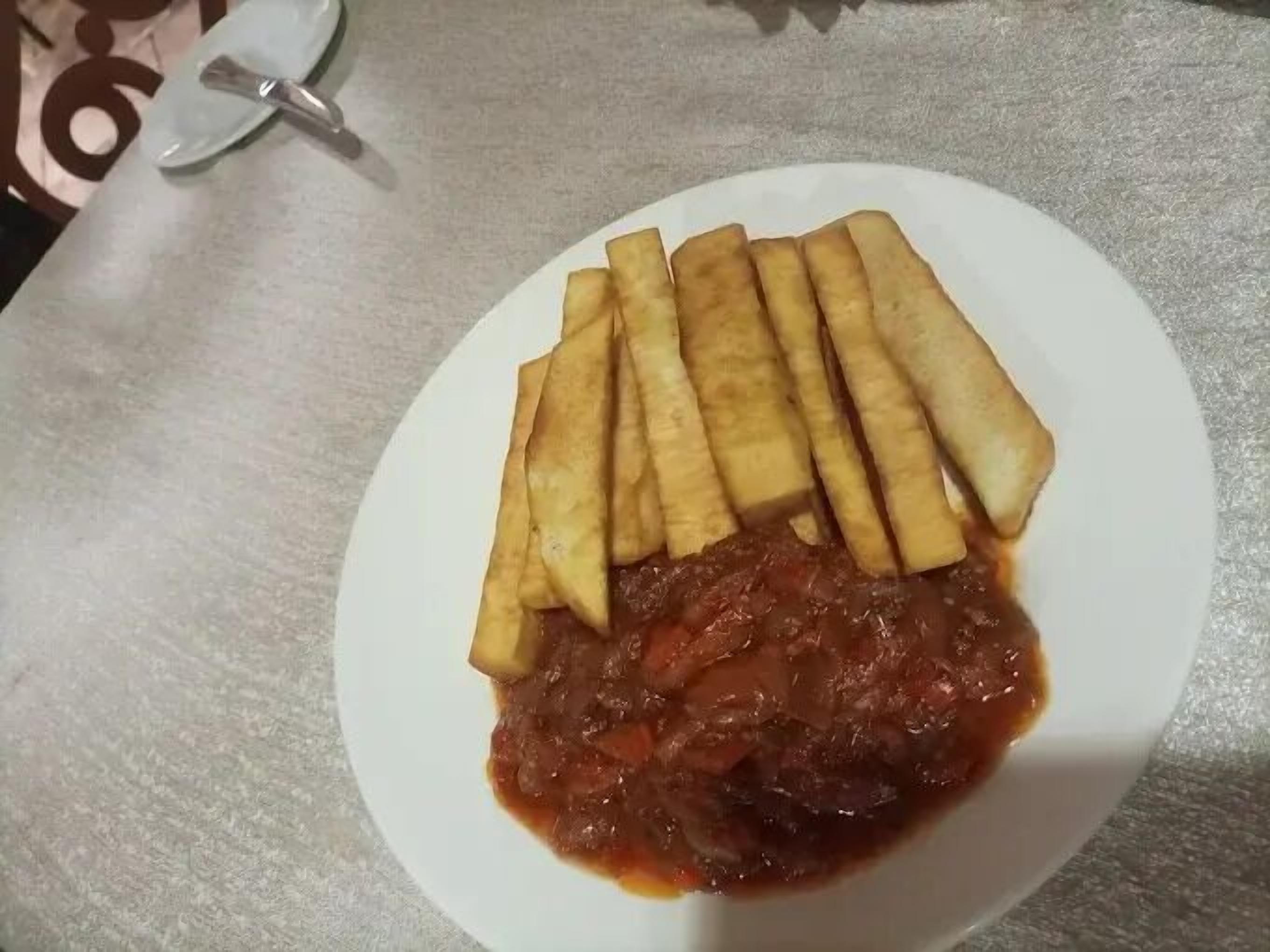 Een bord met gefrituurde snacks en een tomatensaus.