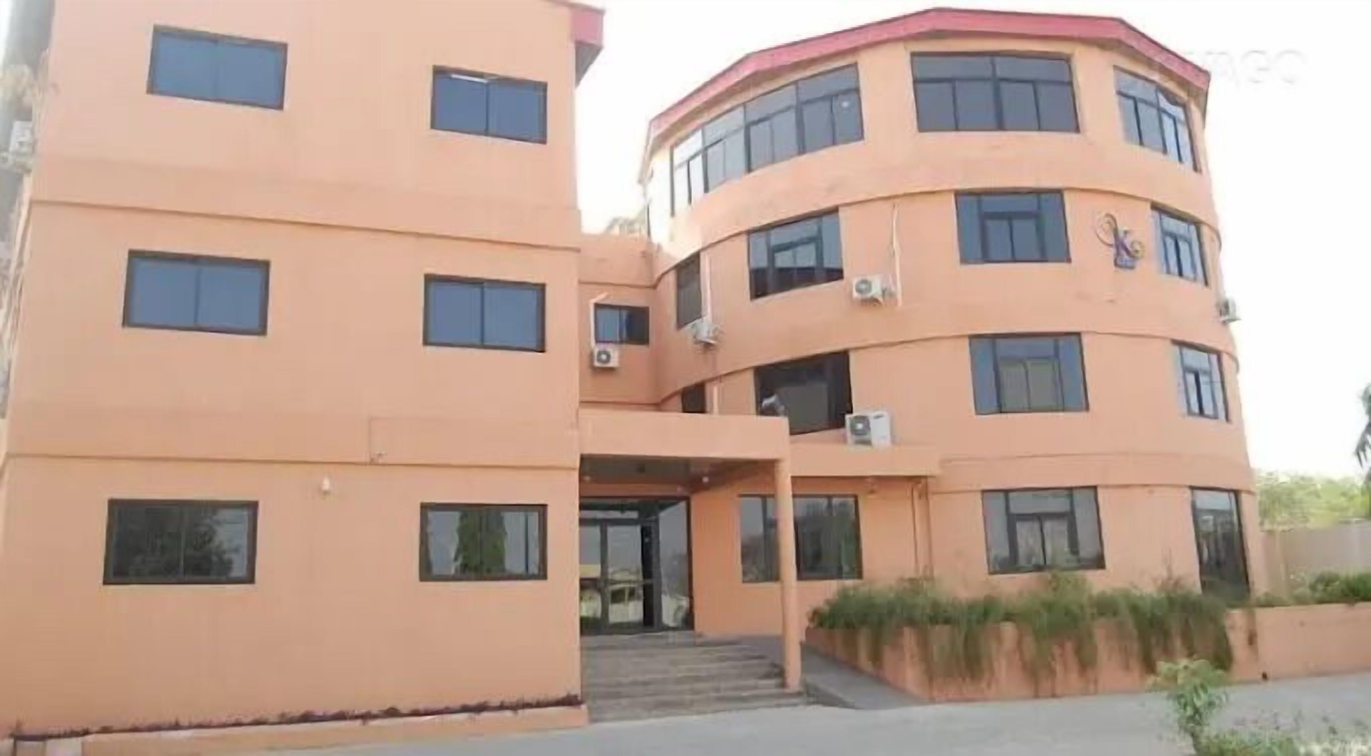 Un edificio de varios pisos con fachada curva, múltiples ventanas y unidades de aire acondicionado.