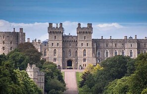 A large, historic castle with multiple towers and a central entrance.