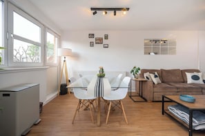 Una sala de estar moderna con una mesa de comedor, sofá y un radiador.