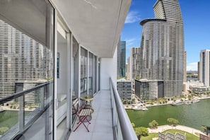 Ein Balkon mit Blick auf hohe Gebäude und ein Gewässer.