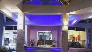 A hotel entrance with a glass door, steps leading up to it, and potted plants on either side. - De Guest Pride Hotel and Suites (Kano)