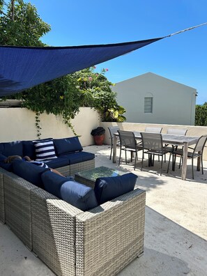 An outdoor seating area with a wicker sofa, a table, and chairs. - Tranquil, Roomy Getaway - Close to City of Hamilton (Pembroke)