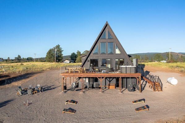 A modern, triangular building with a deck and outdoor seating area.