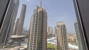 A high-rise building with a prominent tower, surrounded by other tall buildings and a body of water.