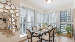 A dining area with a glass table, six chairs, and a wall of circular mirrors.