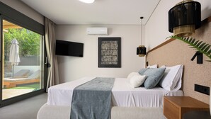 Un dormitorio moderno con una cama grande, televisión y ventana con vistas al exterior.