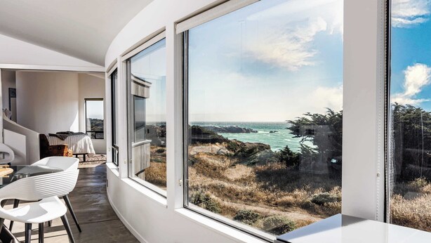 Un intérieur moderne avec de grandes fenêtres donnant sur la côte.
