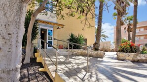 A hotel entrance with a staircase, palm trees, and a sign reading 'CHASNA C. Calle Chasna No 6.' - 'Chasna' Holidays with Shared Pool, Shared Garden and Wi-Fi (Arona)