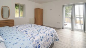 Une chambre à coucher avec un lit, une armoire en bois, un radiateur et une fenêtre.