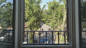 Ein Fenster mit Blick auf eine Straße und Bäume.