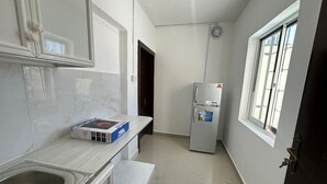 A compact kitchen with a sink, a countertop, a refrigerator, and a window. - Private Studio attach washroom, kitchen, Terrace (Abu Dhabi)