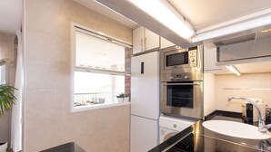 A modern kitchen with a built-in oven, microwave, and stainless steel appliances.