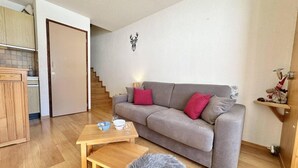 A living room with a grey sofa, wooden coffee table, and a fluffy rug.