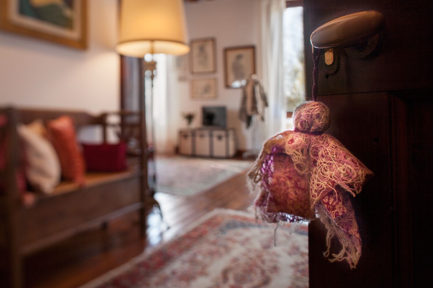 Ein gemütliches Wohnzimmer mit einem gemusterten Teppich, einer Holzkommode und einer Lampe.