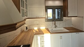 A kitchen with wooden countertops, white cabinets, a built-in window, and a sink. - Prime Views A - Peacefull Villa with Private Pool, premium Sea view and Sunsets. (Poseidonia)