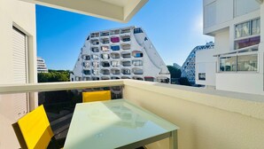 Een modern gebouw met een uniek architectonisch ontwerp, met balkons en een glazen tafel op een balkon.