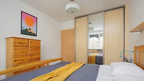 Ein Schlafzimmer mit einem Bett, einer Holzkommode und einem Schiebetürenschrank.