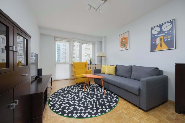 A modern living room with a grey sofa, yellow armchair, and a patterned rug. - Spacious Apartment | Two Bedrooms and Balcony (Warszawa)