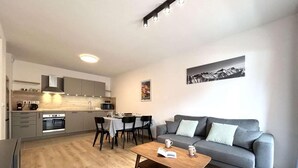 Un appartement moderne comprenant une cuisine, un coin repas et un salon.
