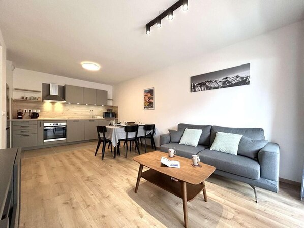 A modern apartment with a kitchen, dining area, and living room.