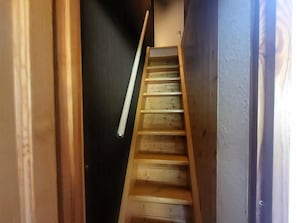 A wooden staircase leading to a dark room.