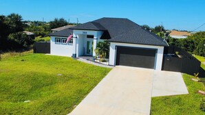 Una moderna casa a due piani con garage, vialetto e prato curato.