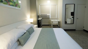 A hotel room with a bed, a desk, a chair, a mirror, and a window. - Near Old San Juan Zero-cost Parking A C (San Juan)