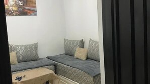 A small, compact room with two beds, a bench, and a wall-mounted picture. - Studio Nahid 3rd floor free wifi (Tanger)