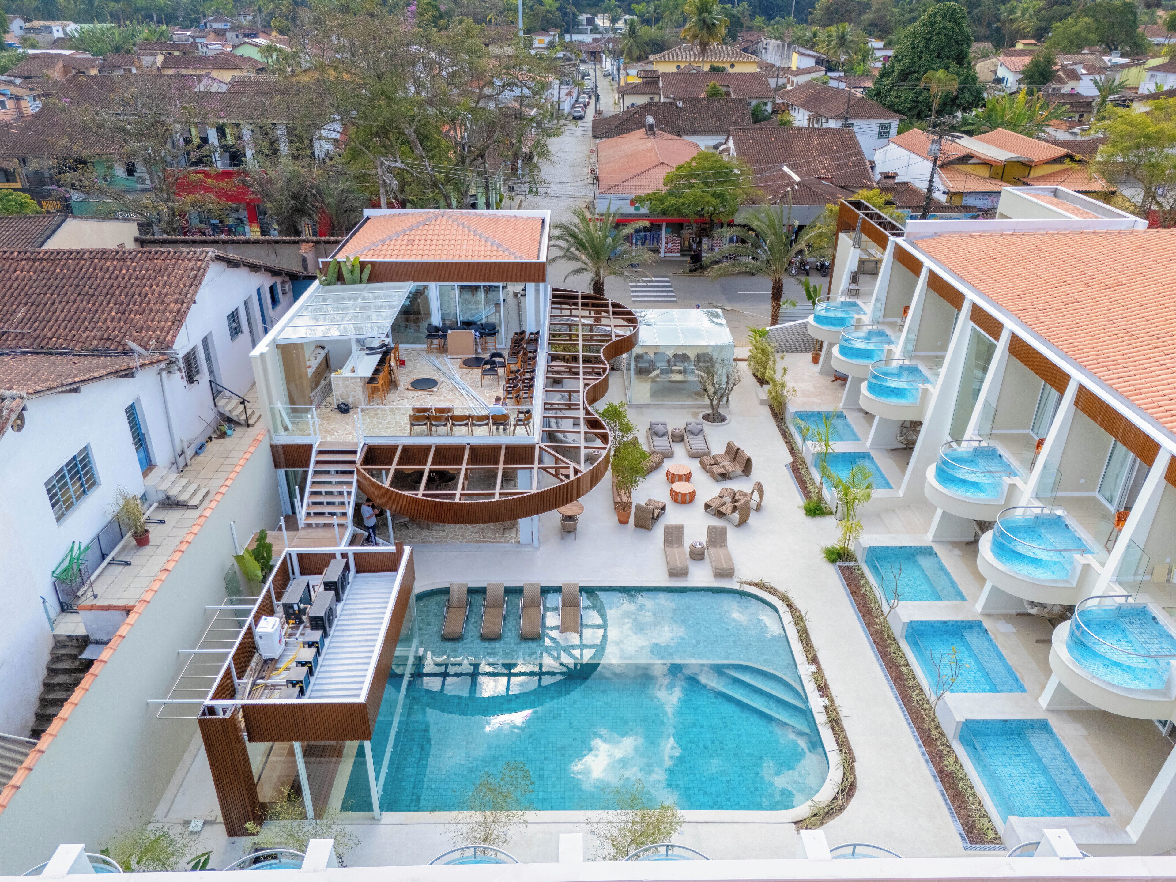 Un hôtel doté d’une piscine centrale, d’un espace extérieur aménagé et d’un escalier en colimaçon.